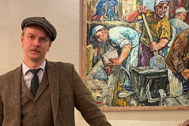 Emil Bladelius står i en trappa invid en stor målning