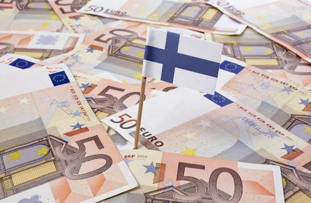 En finsk flagga nedstucken i en samling Euro-sedlar.