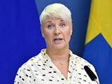 Moderatpolitikern Anna Tenje med en svensk flagga i bakgrunden.