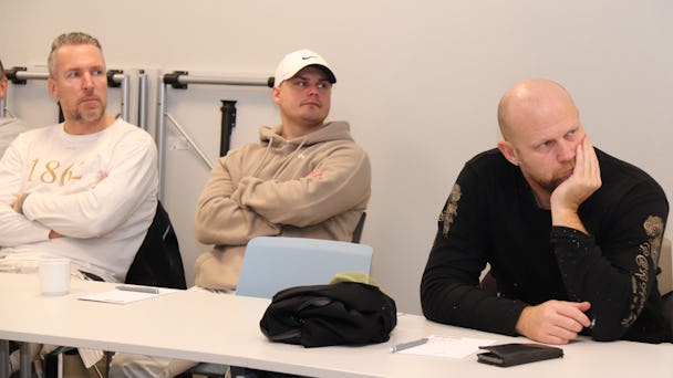 Tre medlemmar lyssnar på information.