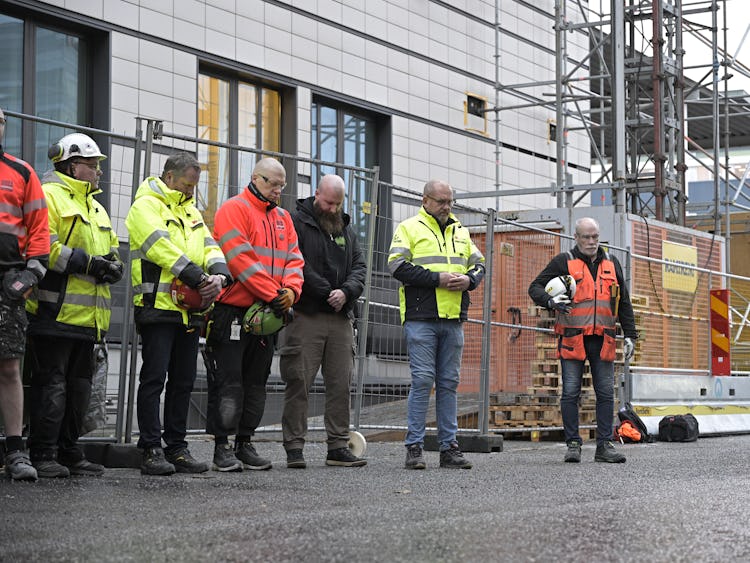 Byggnadsarbetare på en arbetsplats i Solna håller en tyst minut.