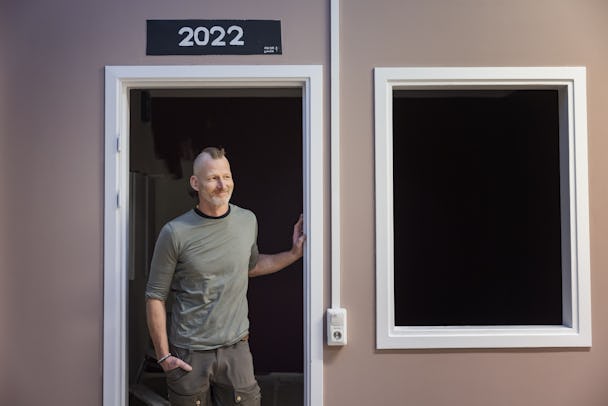 Mikael Söderström som står i dörröppningen till ett låtsashus i ett måleriklassrum.