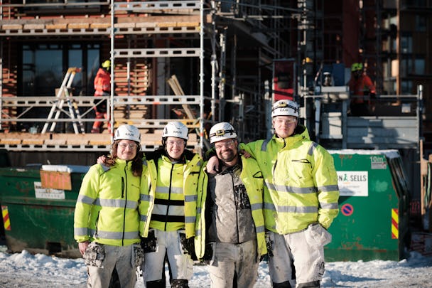 Natalie och tre kollegor poserar framför en byggnad som håller på att byggas.